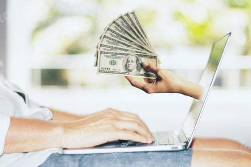 Preview: Hand With Dollars Sticking Out Of Laptop Screen. Cryptocurrency And Payment Concept