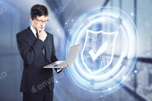 Preview: Attractive Young European Businessman Using Laptop On Blurry Office Interior Background With