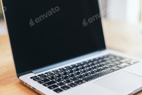 Preview: Side View Of Blank Laptop Computer Screen On Wooden Desktop. Blurry Background. Technology