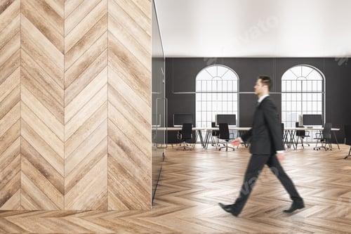 Preview: Attractive Young Businessman Walking In Wooden Office. Executive And Research Concept.