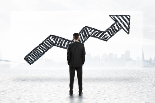Preview: Back View Of Young Businessman Looking At Banner With Drawn Arrow On Abstract City Background