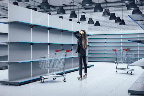 Preview: Businesswoman With Shopping Trolley Cart Looking On Empty Retail Shelves. Business And Retail