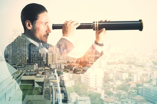 Preview: Side View Of Young Businessman Using Binoculars To Look Into The Future On Abstract City