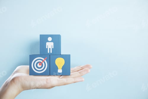 Preview: Hand Holding Business Sign On Black Cubes On Blue Background. Success And Startup Concept.