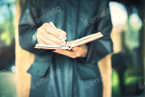 Preview: Front View Of Hands Holding And Writing In A Notebook