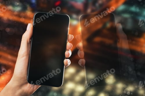 Preview: Hand Holding Empty Black Cellphone With Reflection On Blurry Night City Background. Mock Up