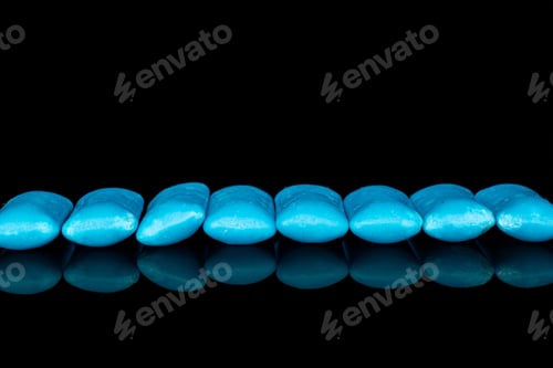 Preview: Group Of Eight Whole Blue Chewing Gum Line Isolated On Black Glass