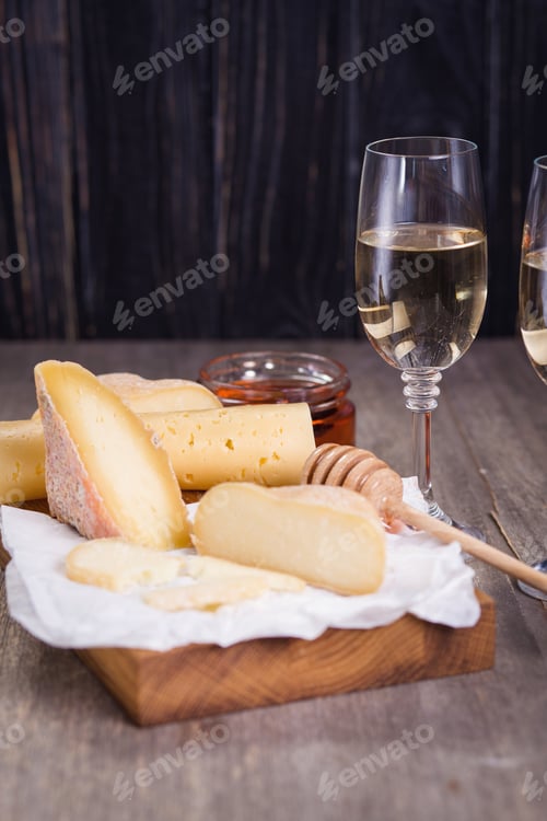 Preview: White Wine In Glasses And Several Types Of Cheese On Wooden Plate