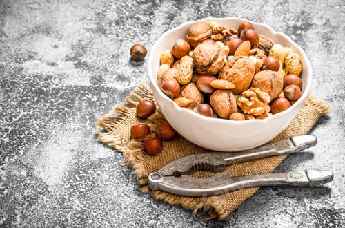 Preview: Various Nuts In A Bowl With A Nutcracker. On Rustic Background.