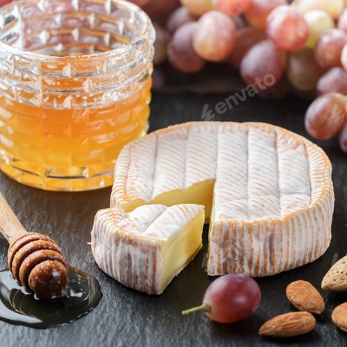 Preview: Delicatessen Soft Fragrant Cheese With Mold, Honey, Almonds And Red Grapes On A Black Slate Plate