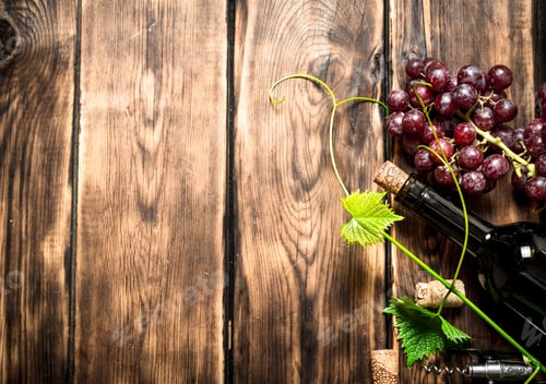 Preview: Bottle Of Red Wine With A Sprig Of Grapes. On A Wooden Table.
