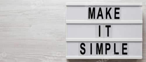 Preview: 'Make It Simple' Words On A Lightbox On A White Wooden Surface, Overhead View. Top View, From