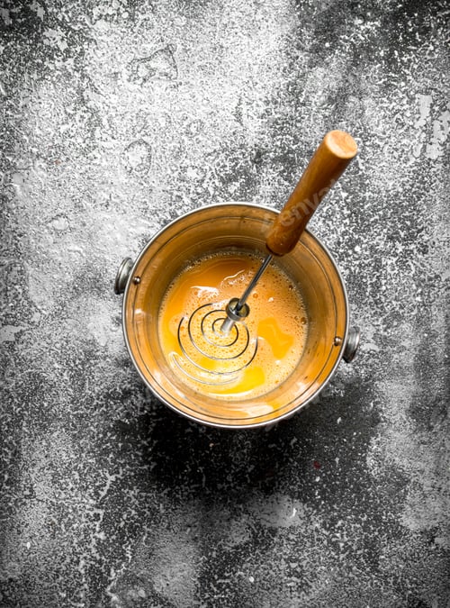 Preview: Baking Background. Whisking Fresh Eggs In A Bucket On A Rustic Background.
