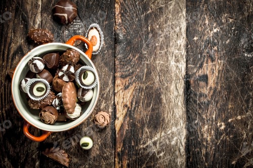 Preview: Chocolate Candies In A Bowl. On A Wooden Background.