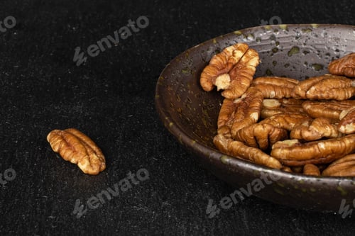 Preview: Lot Of Whole Tasty Brown Pecan Half In Glazed Bowl On Grey Stone