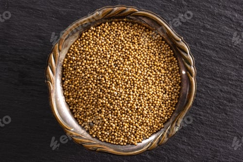 Preview: Lot Of Whole White Mustard Seeds In Old Iron Bowl Copyspace Flatlay On Grey Stone