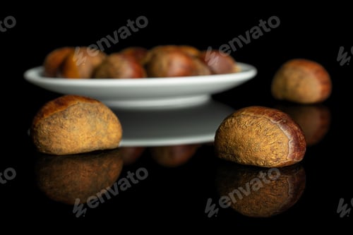 Preview: Lot Of Whole Sweet Brown Chestnut On White Ceramic Plate Isolated On Black Glass