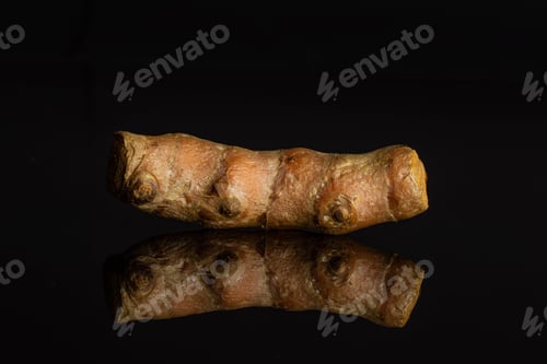 Preview: One Whole Pungent Bright Turmeric Rhizome Isolated On Black Glass