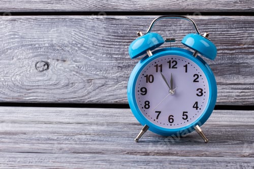 Preview: Bright Blue Vintage Alarm Clock On Gray Wooden Background. Five To Twelve On The Clock.