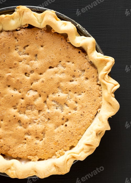 Preview: Homemade Chocolate Walnut Derby Pie Over Black Surface, Top View. From Above, Overhead, Flat Lay