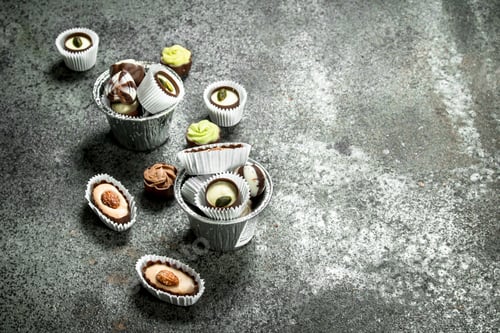 Preview: Chocolate Candies In A Bowls. On A Rustic Background.