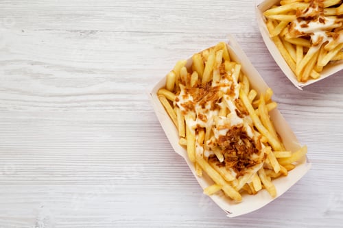 Preview: Fastfood: French Fries With Cheese Sauce And Fried Onion In Paper Boxes On A White Wooden