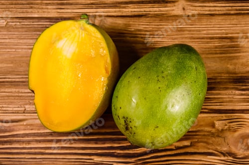 Preview: Halved Mango Fruit On Rustic Wooden Table. Top View