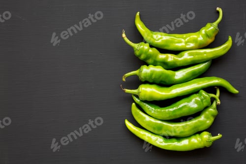 Preview: Top View, Green Chili Peppers On Black Surface. Flat Lay, From Above, Overhead. Copy Space.