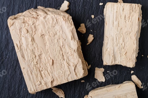 Visualização: Fermento fresco no closeup cinza da mesa. Ingrediente para assar pão e produtos de panificação. Seletivo