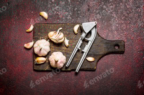 Preview: Garlic Bulbs with Garlic Press on Cutting Board