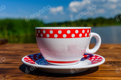 Preview: Cup Of Coffee On Rustic Wooden Table At The Riverside