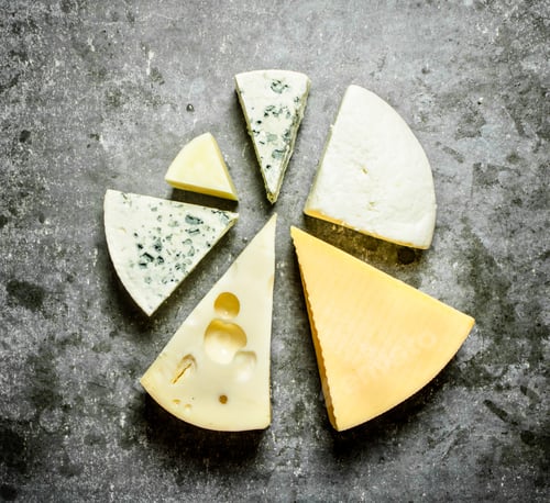 Preview: Various Pieces Of Cheese Around. On The Stone Table.