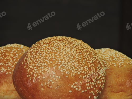 Preview: Bread Rolls With Sesame Seeds Isolated On A Black Background. Close Up.