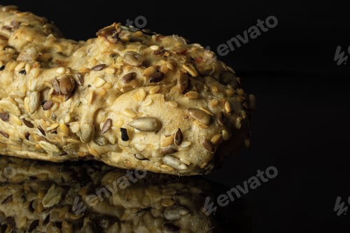 Preview: Closeup Of One Whole Fresh Cereal Baguette Isolated On Black Glass