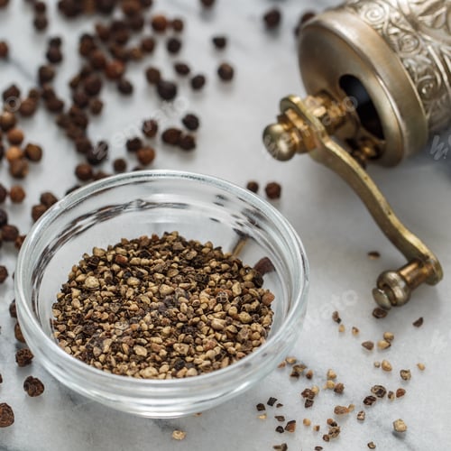 Preview: Organic Dried Black Peppercorns And Coarse Ground Pepper In A Bowl On A Marble Background Close-Up