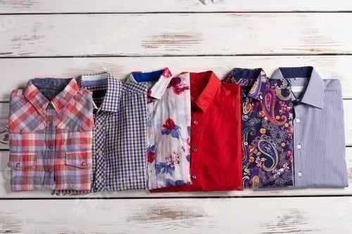 Preview: Selection of Folded Shirts on White Wood Surface