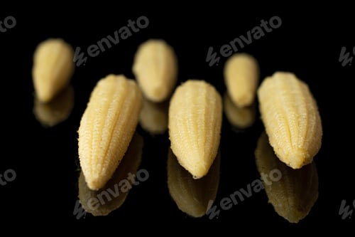 Preview: Group Of Six Whole Baby Yellow Corn Isolated On Black Glass