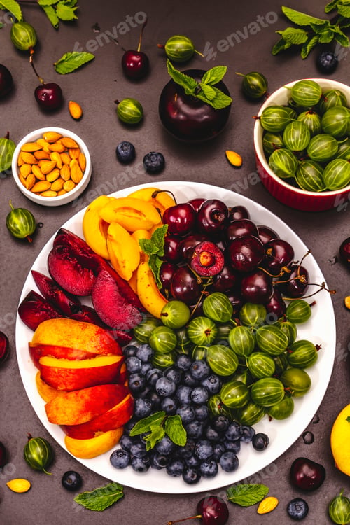 Vista previa: Assorted Fresh Fruits On A Plate. Ripe Berries Of A Cherry, Gooseberry, Blueberries, Slices Of