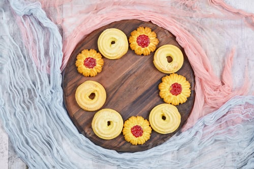 Preview: Assorted Biscuits On The Wooden Plate With Pink And Blue Tablecloths