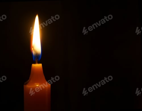 Preview: Burning Candle On A Black Background.