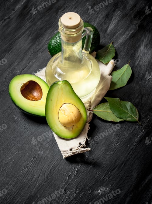 Preview: Oil And Avocados. On A Black Wooden Background.