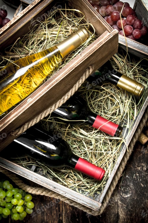 Preview: Wine Background. Bottles Of Red And White Wine In Old Boxes. On A Wooden Background.