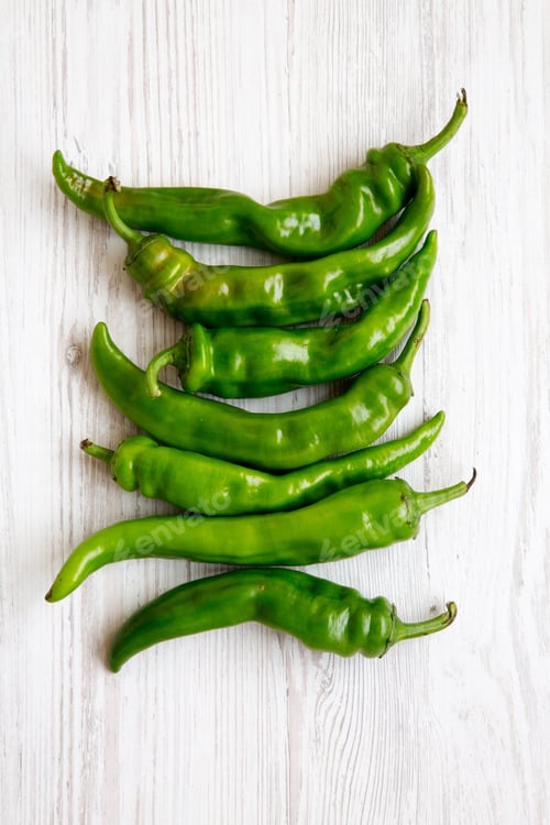 Preview: Green Chili Peppers On White Wooden Surface, Top View. Flat Lay, From Above, Overhead. Close-Up.