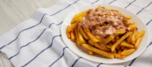 Preview: Homemade Animal Style French Fries On A White Plate, Low Angle View. Copy Space.