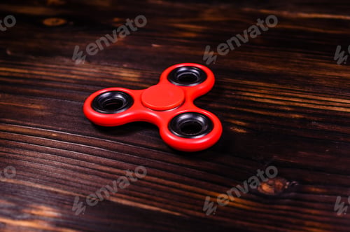 Preview: Red Fidget Spinner On Rustic Wooden Desk
