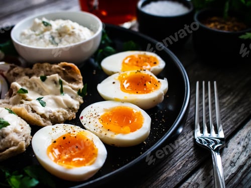 Preview: Delicious Breakfast - Soft Boiled Eggs With Cottage Cheese And Vegetables Served On Black Plate On
