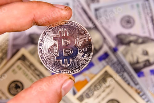 Preview: Hand With Bitcoin Against One Hundred Dollar Bills