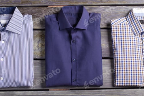 Preview: Folded Shirts on a Rustic Wooden Surface