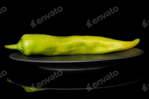 Preview: One Whole Hot Green Pepper Banana On Gray Ceramic Plate Isolated On Black Glass