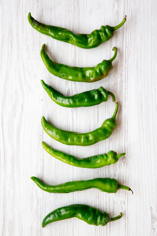 Preview: Green Pepperoni Peppers On White Wooden Table, Top View. Flat Lay, From Above, Overhead.